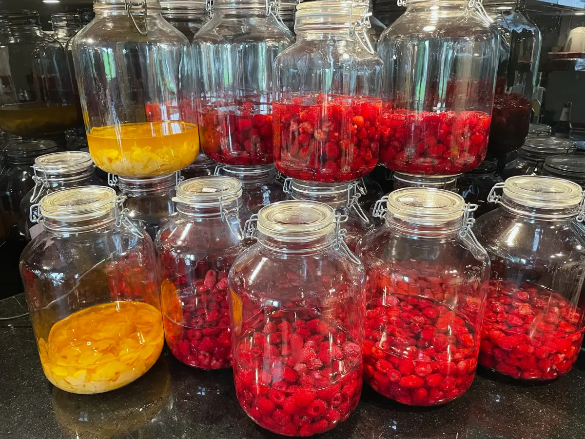Bonbonnes de macération de framboises et d'abricots à l'atelier